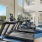 rows of treadmills in a high-ceiling fitness center room