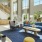 a spacious lounge room with high ceilings, seating and ample-natural lighting