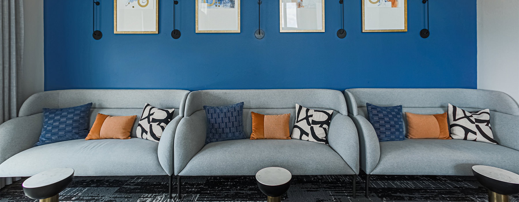 Gray couches in a lounge room with a blue wall