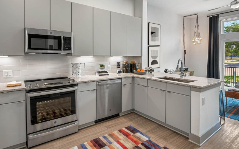 a kitchen with modern appliances and patio views connected to room